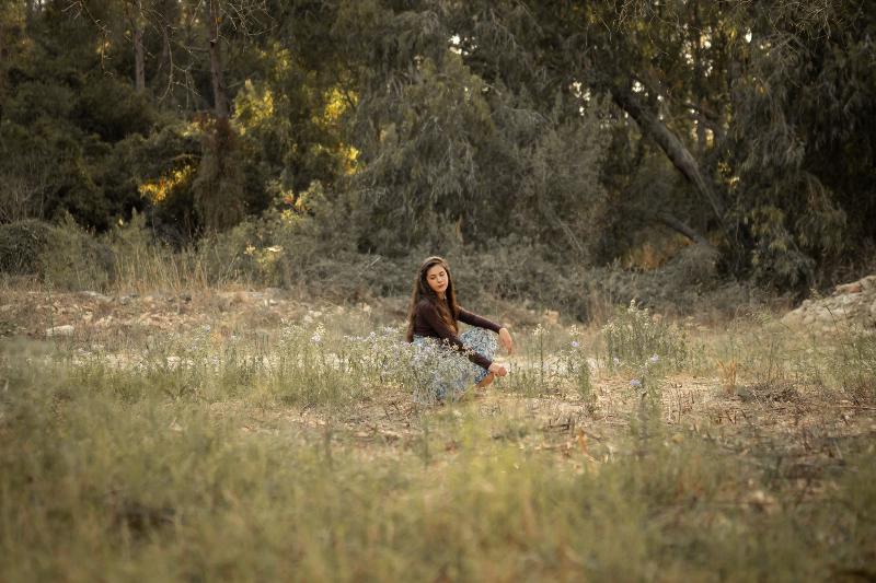 נערה יושבת בשדה פרחי בר בשולי יער — בוק בת מצווה בטבע