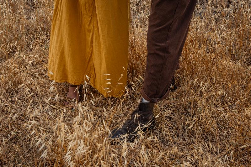 שמלה צהובה ומגפי עור בתוך שיבולים — פרט מצילומי זוגיות